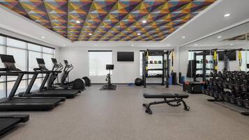 A gym with treadmills, a stationary bike, and weightlifting equipment.