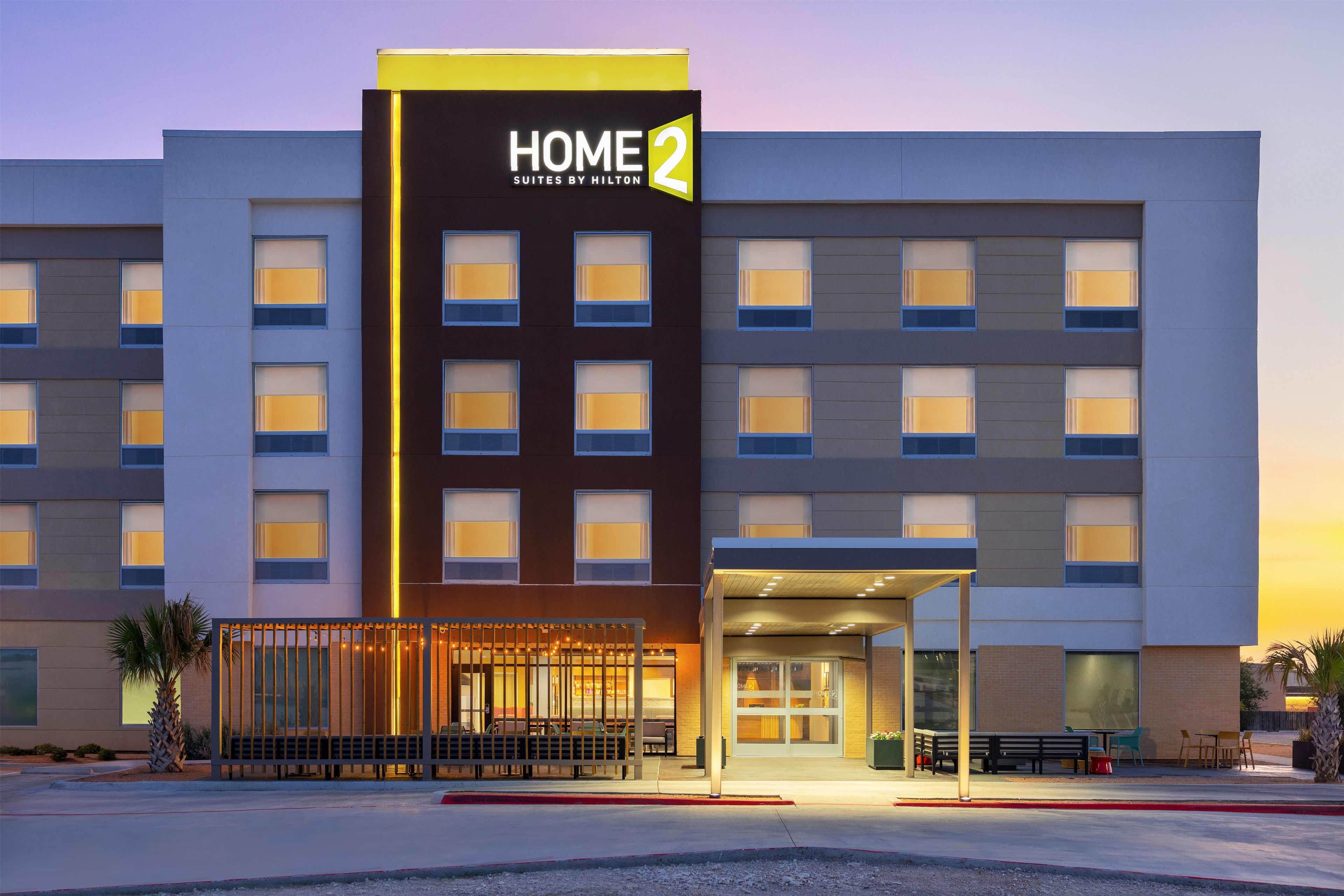 A hotel with a prominent 'HOME 2' sign, multiple windows, and a covered entrance area.
