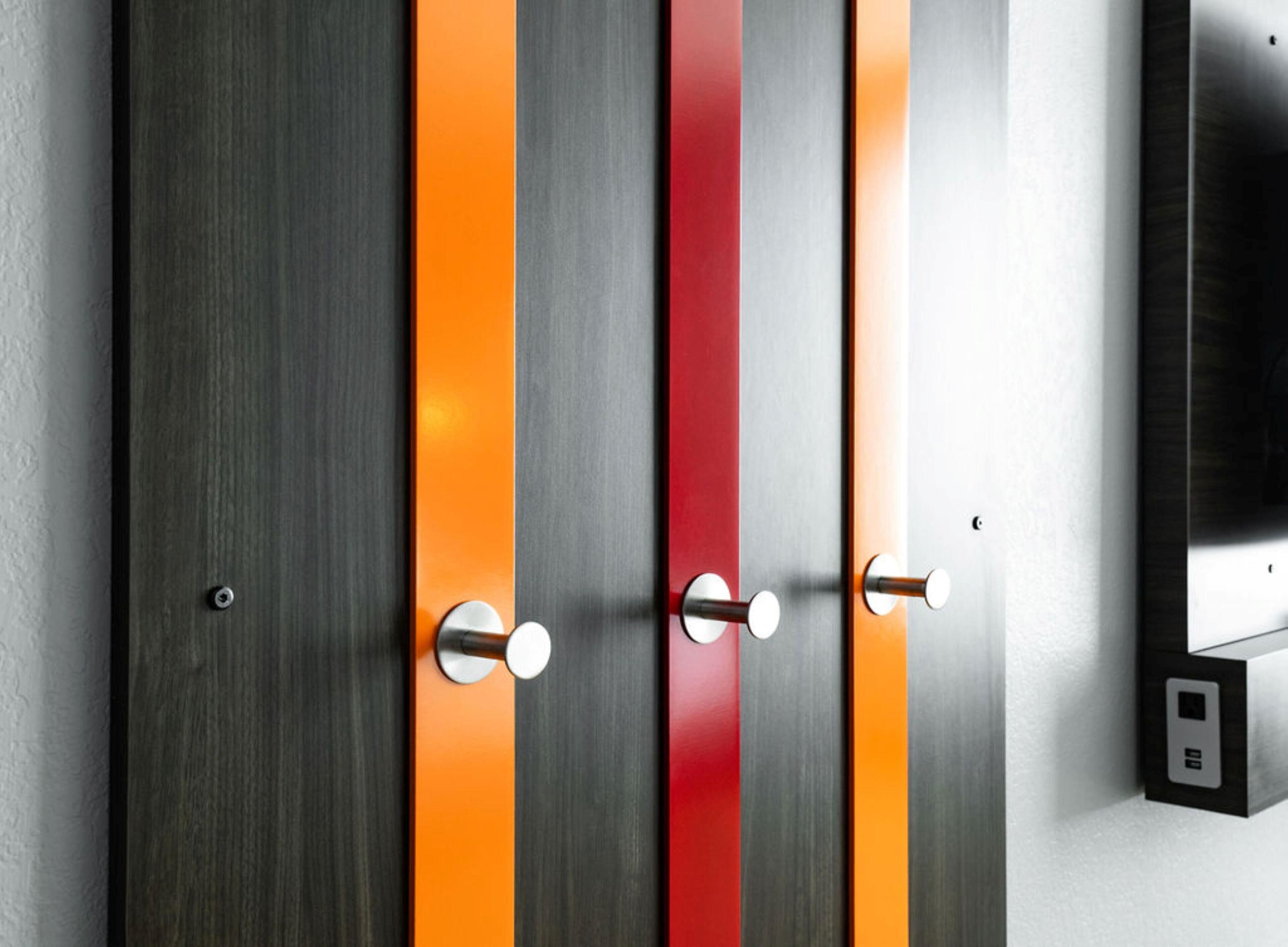 Une porte moderne dotée de trois poignées verticales et d’un panneau de commande situé à droite.