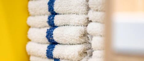 A stack of white towels with blue stripes.