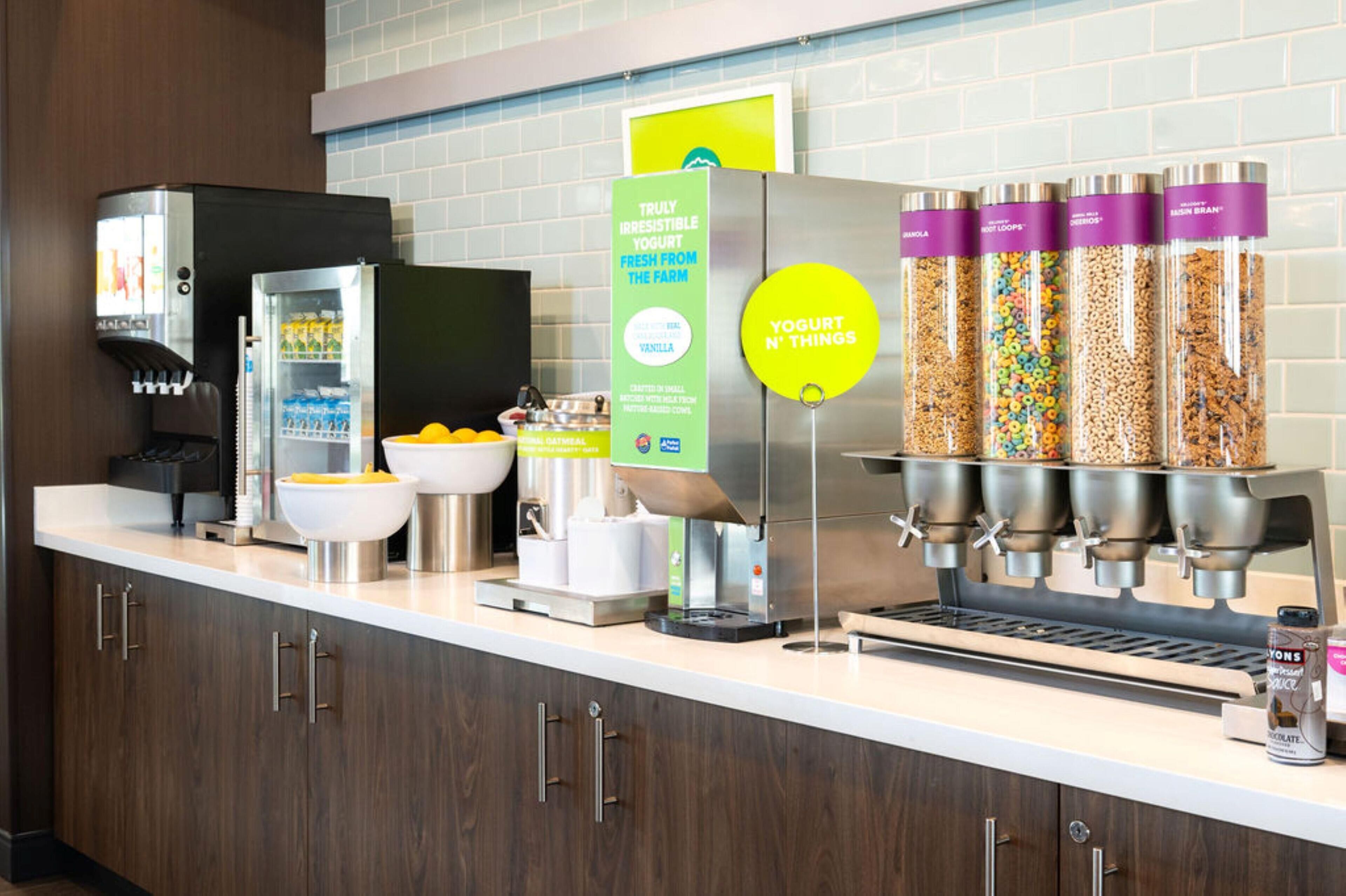 A self-serve station with yogurt, granola, and cereal options.