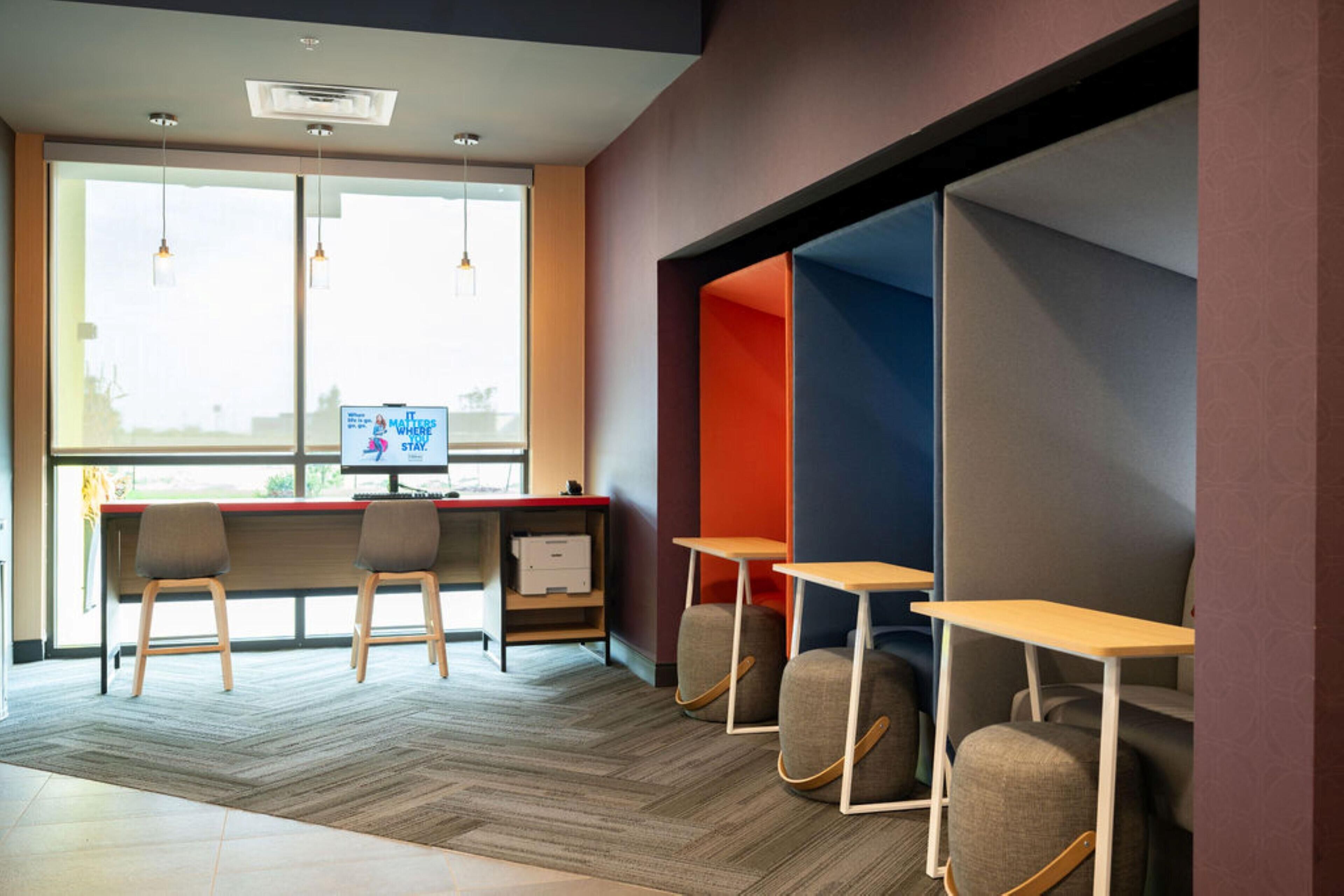 A modern office space with a desk, chairs, and a computer monitor.