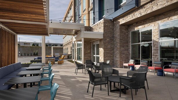 An outdoor patio area with seating arrangements, tables, and a covered section. - Home2 Suites By Hilton Hickory (Hickory)