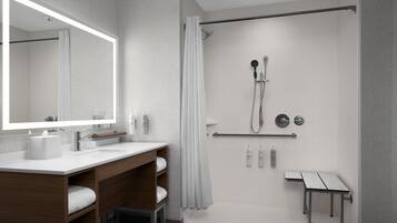 A modern bathroom with a shower, a vanity with a mirror, and a towel rack.