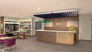 A modern hotel lobby with a reception desk, a snack area, and a seating area with tables and chairs. - Home2 Suites By Hilton Hickory (Hickory)