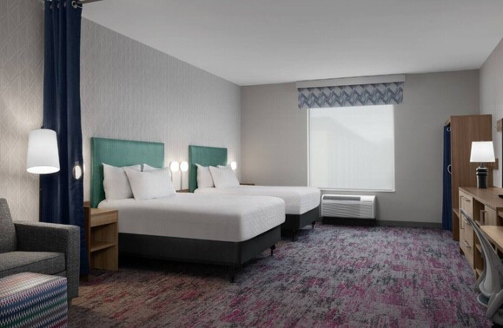 A hotel room with two beds, a desk, a chair, a window with a view, and a radiator.