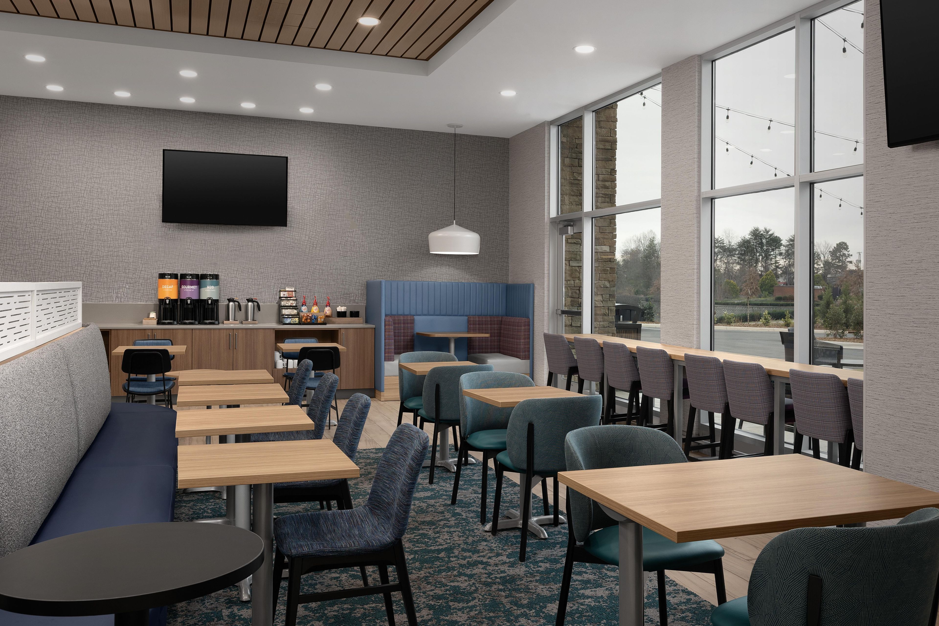 A modern restaurant with a bar area, seating, and a large window offering a view.