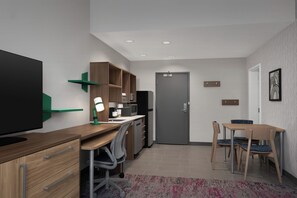 A modern kitchen with a refrigerator, microwave, and wooden cabinets. - Home2 Suites By Hilton Hickory (Hickory)
