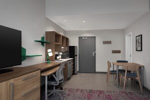 Una cocina moderna con refrigerador, microondas y armarios de madera.
