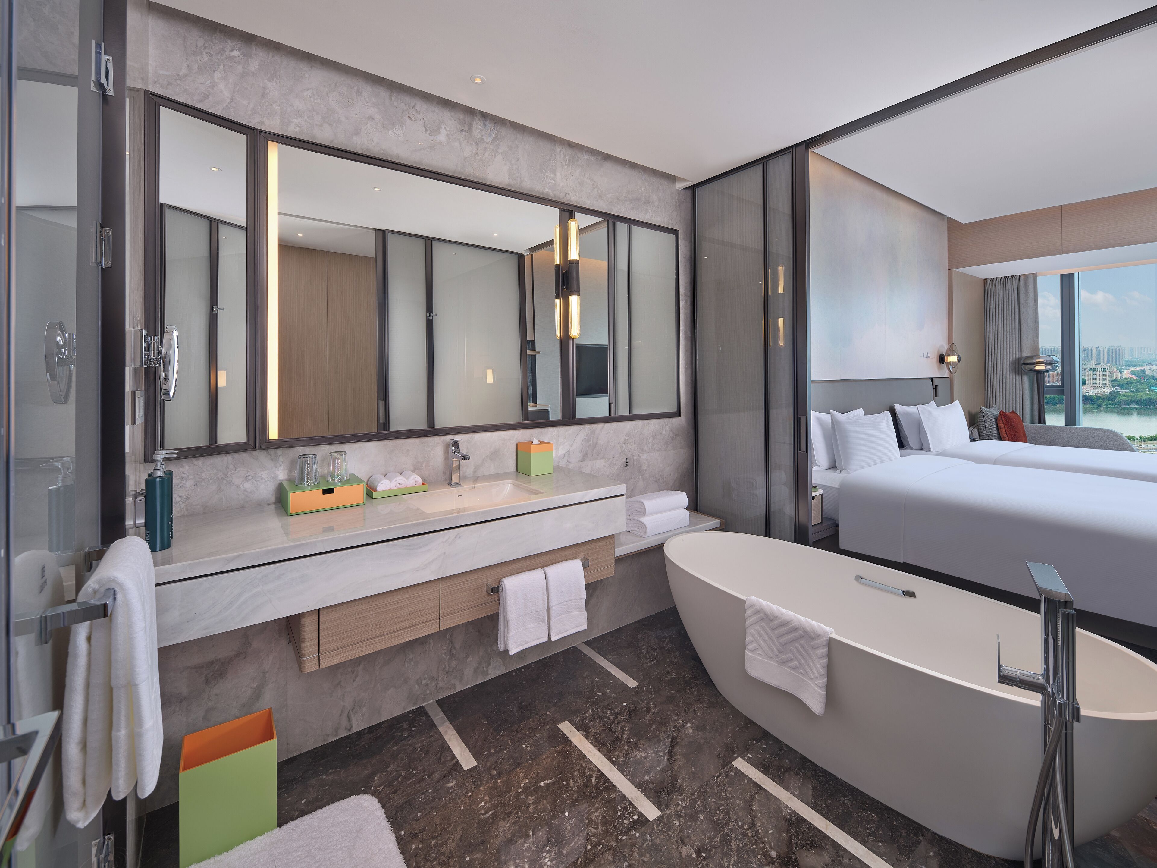 Un baño de hotel moderno con un espejo grande, una bañera, un lavamanos y una ducha.