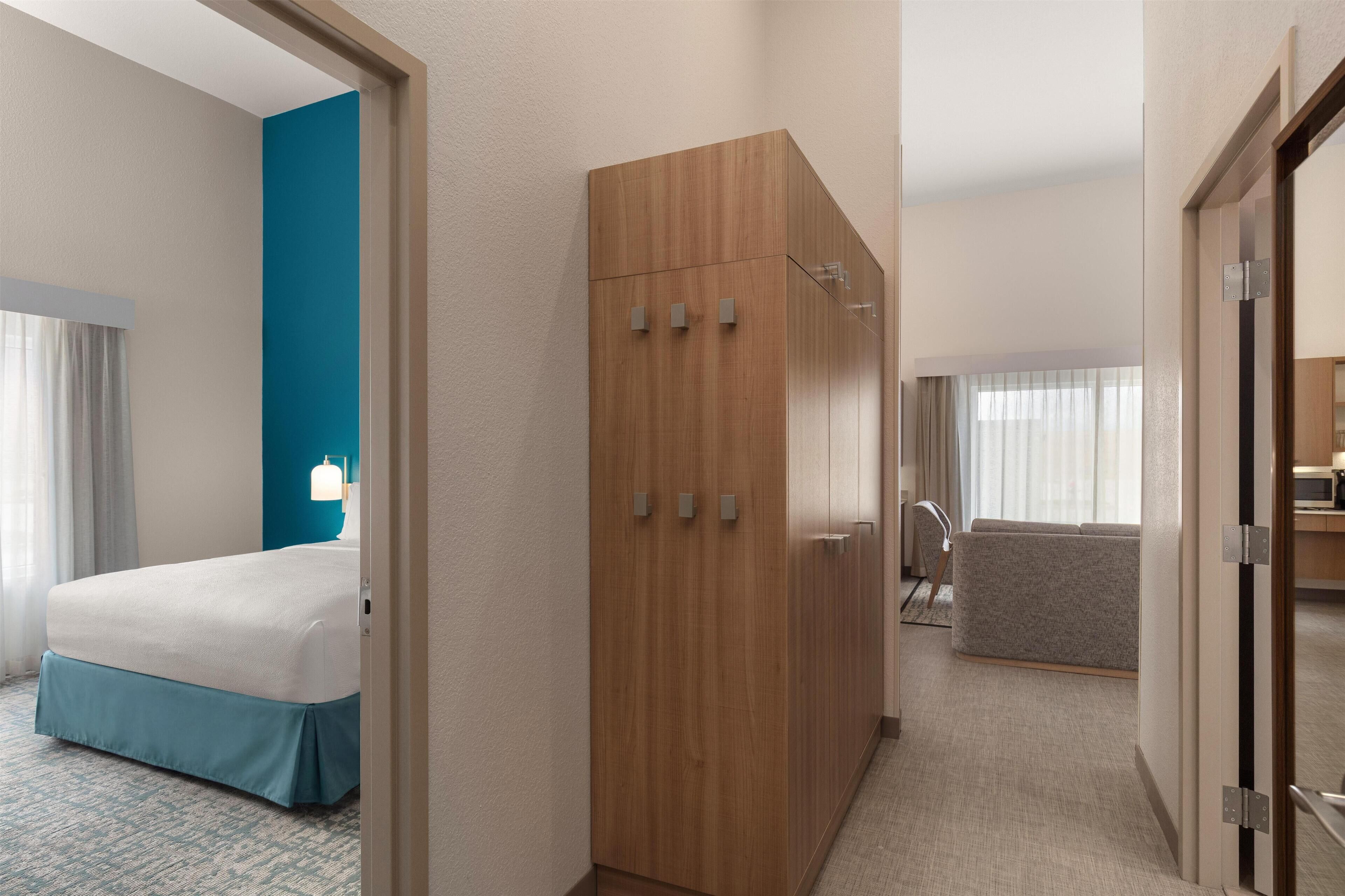 A hotel room with a bed, a wardrobe, a desk, and a sofa.