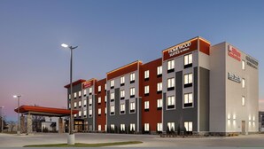 A multi-story hotel with 'Homewood Suites by Hilton' signage, a covered entrance, and a 'Bar Louie' sign. - Homewood Suites By Hilton Wichita Airport (Wichita)