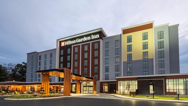 A Hilton Garden Inn hotel with a modern facade, multiple floors, and a well-lit entrance. - Hilton Garden Inn Flushing Laguardia (Flushing)