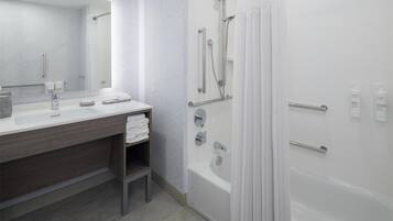 Un baño moderno con un espejo grande, una bañera y una zona de ducha.