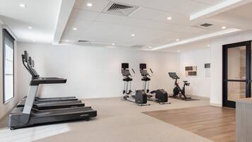 A modern fitness center with treadmills, elliptical machines, and stationary bikes.