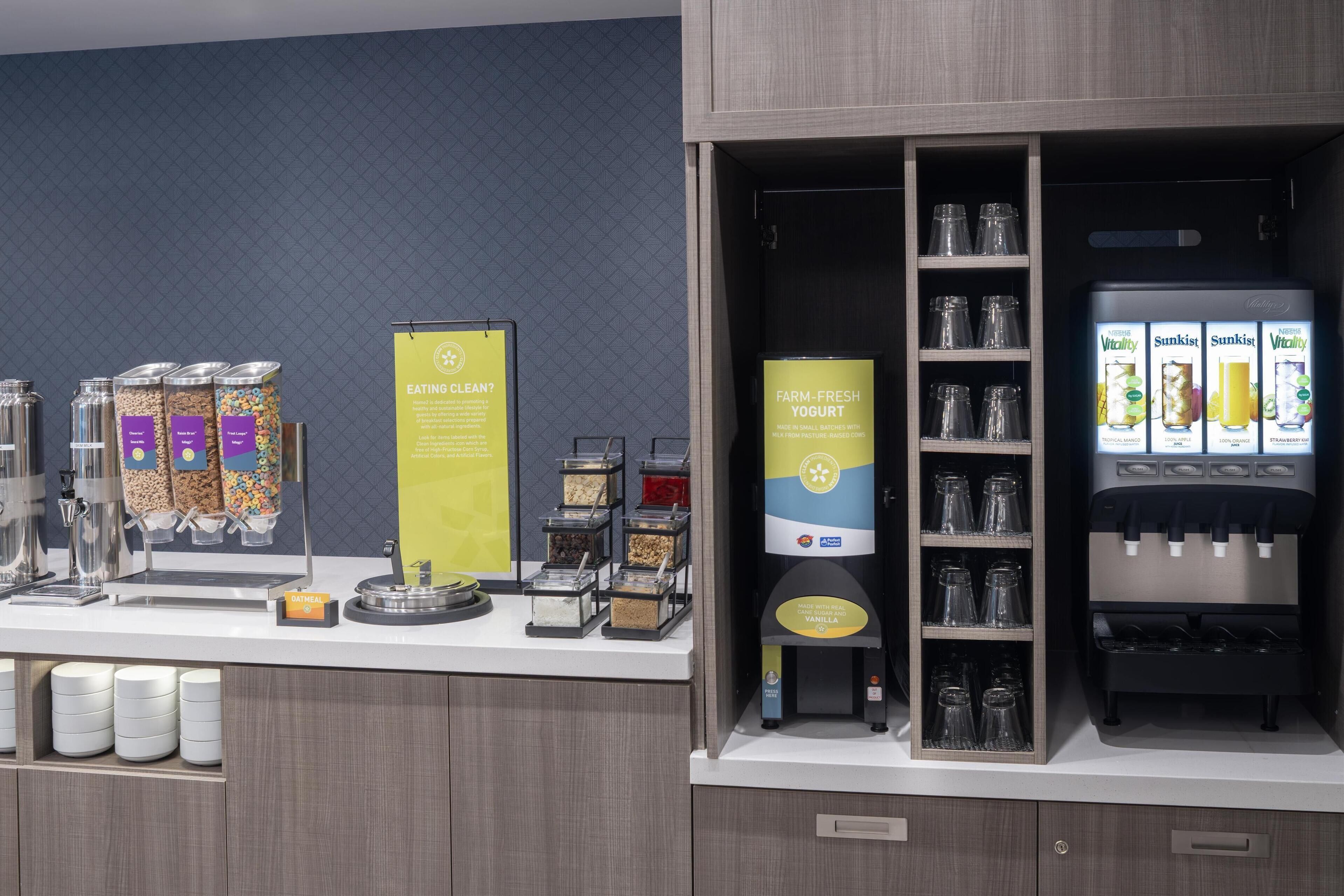 A breakfast bar with various food options, including cereal, oatmeal, and yogurt.