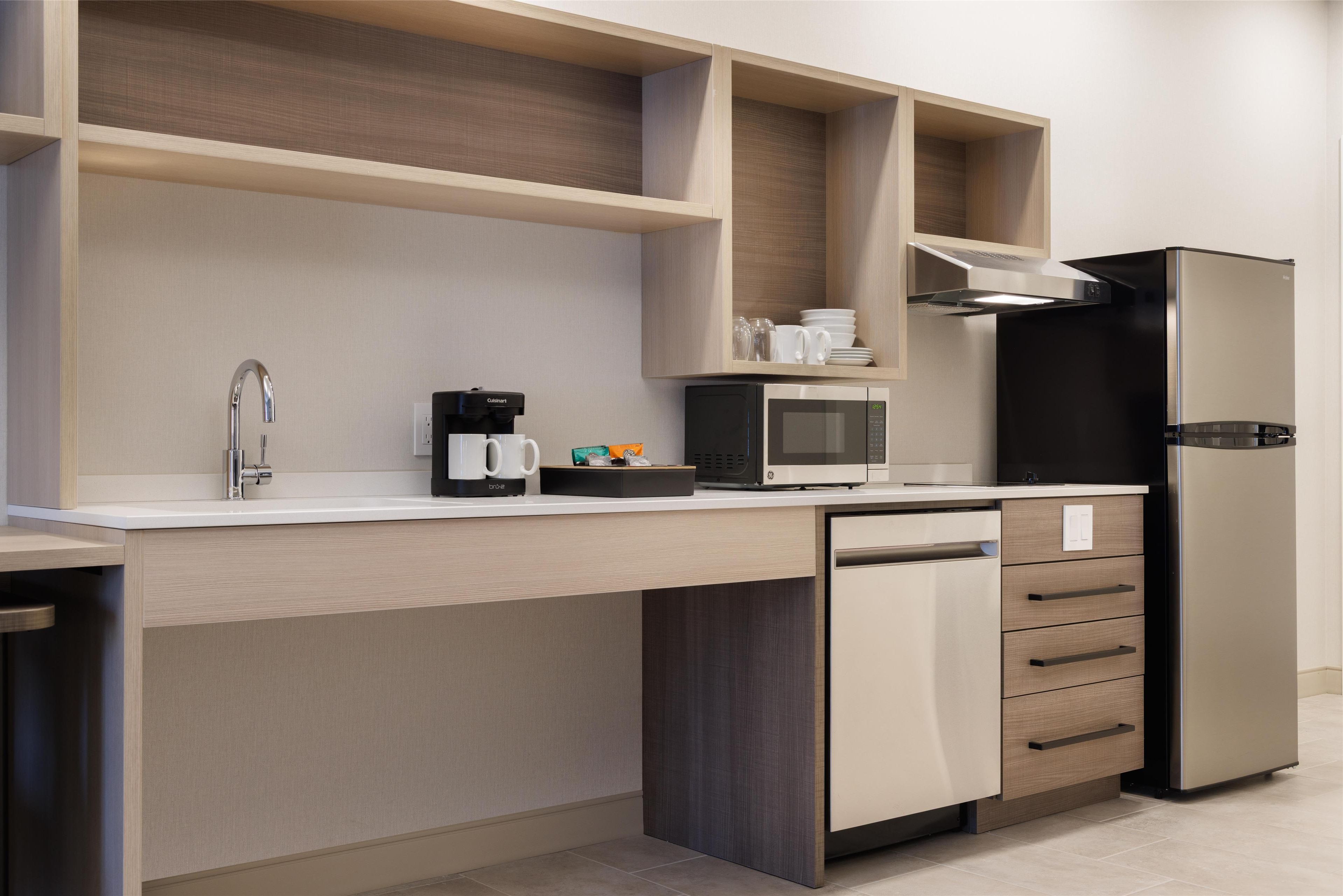 A modern kitchen with a built-in dishwasher, a microwave, and a coffee maker.