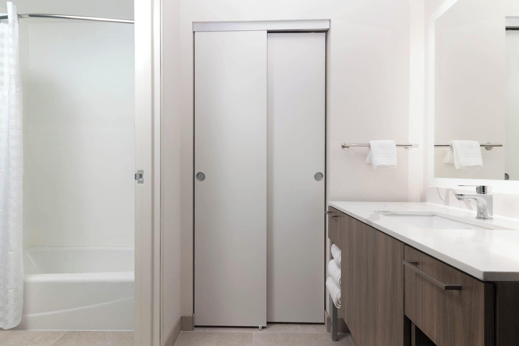 A modern bathroom with a shower, a toilet, and a sink.