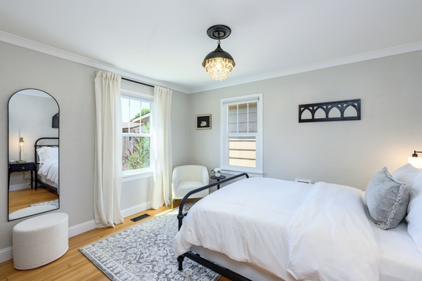 Beautiful master bedroom with Queen size bed, designer lighting & seating area.