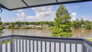 Uitzicht vanaf een overdekt terras op een meer met huizen en steigers.
