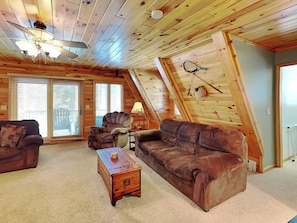 A cozy loft-style room with a sloped ceiling, wooden walls, and large windows. - Walnut Cellars by Taylor Made Deep Creek (Oakland)