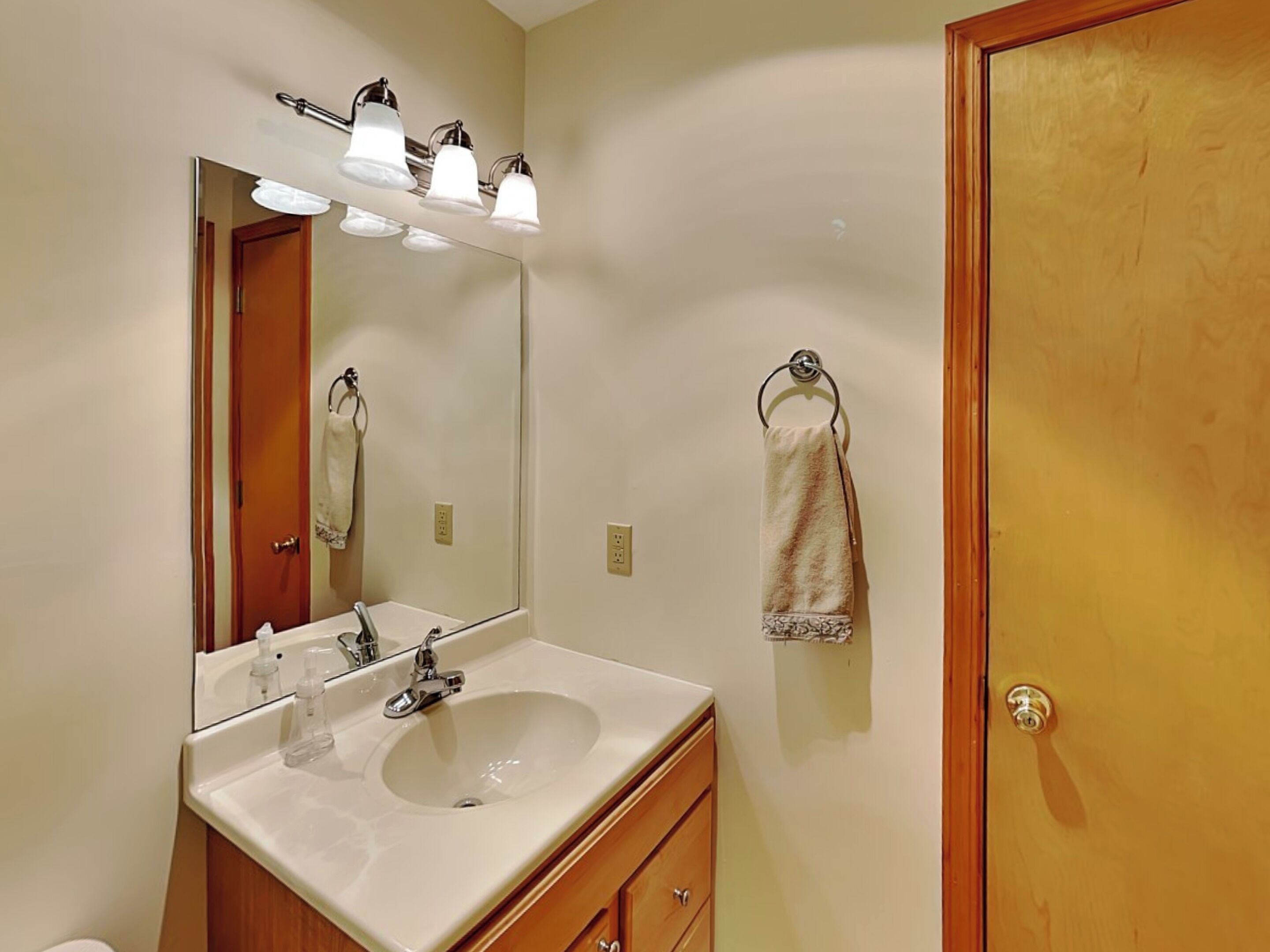 A bathroom with a double sink, a large mirror, and a towel rack.