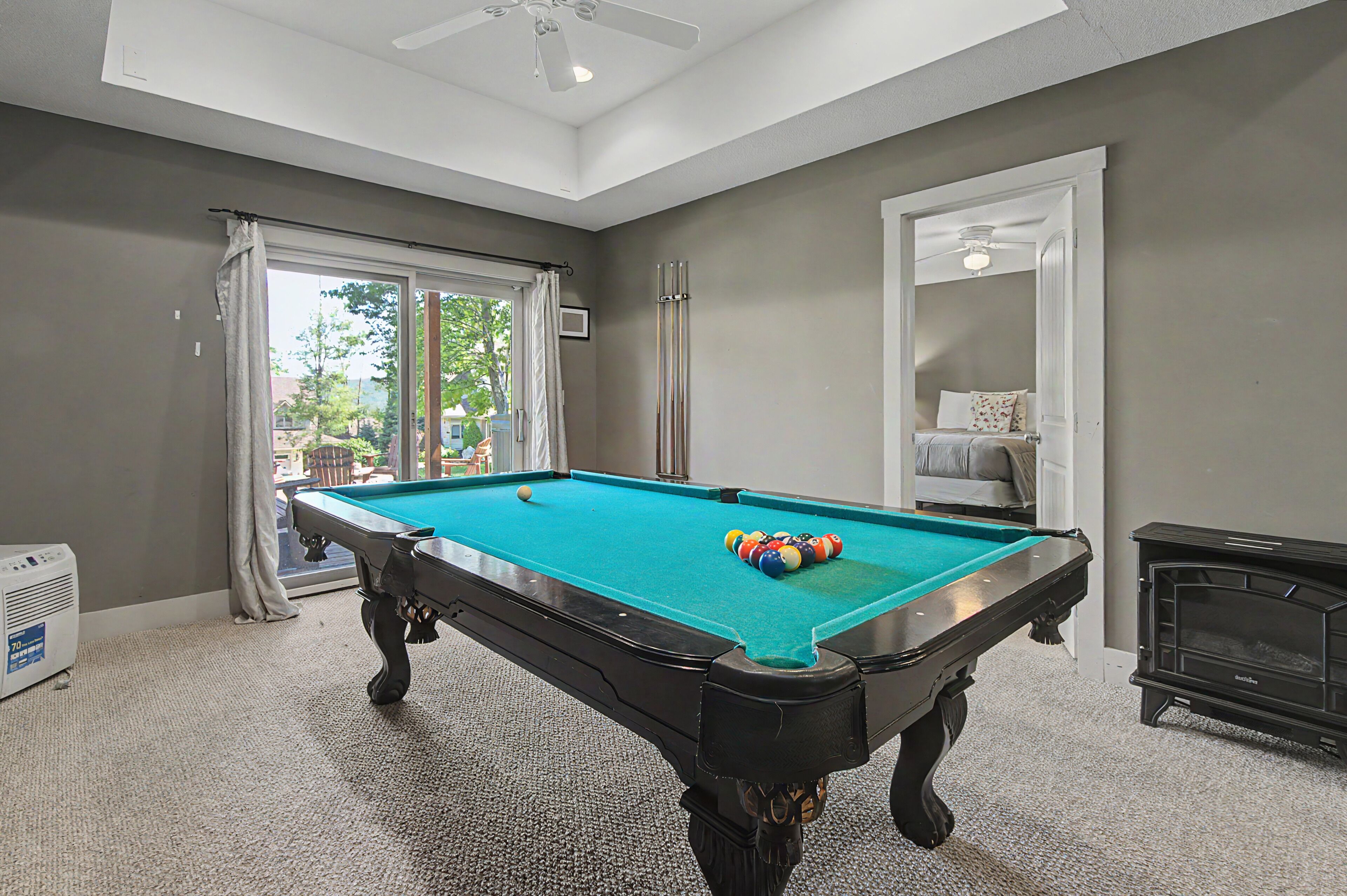 A pool table with balls, a ceiling fan, and a fireplace.