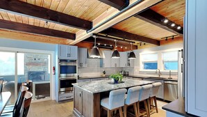 A modern kitchen with a central island, built-in ovens, and pendant lighting. - As You Lake It by Taylor Made Deep Creek (Oakland)