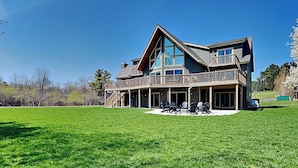 A large, two-story house with a prominent balcony and a spacious lawn. - As You Lake It by Taylor Made Deep Creek (Oakland)