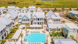 Un resort con varias edificaciones, una piscina y vista al océano.