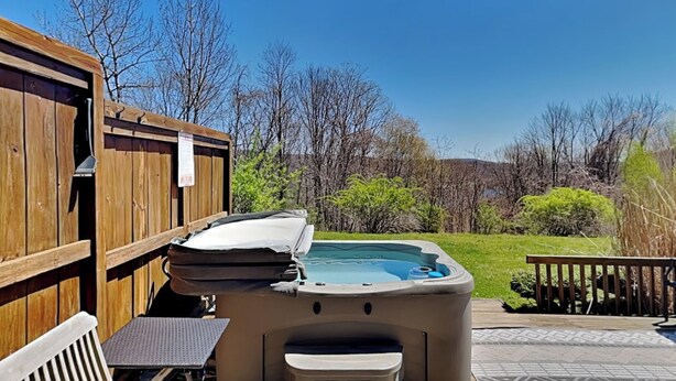 Ein Whirlpool mit Holzterrasse und überdachter Sitzgelegenheit.