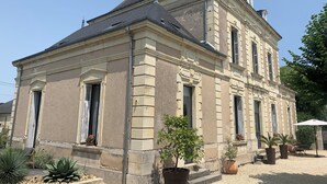 Een groot, historisch gebouw met een symmetrische gevel, meerdere ramen en een centrale ingang.