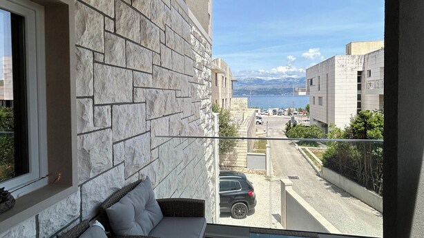 A balcony with a stone wall, a sofa, and a table.