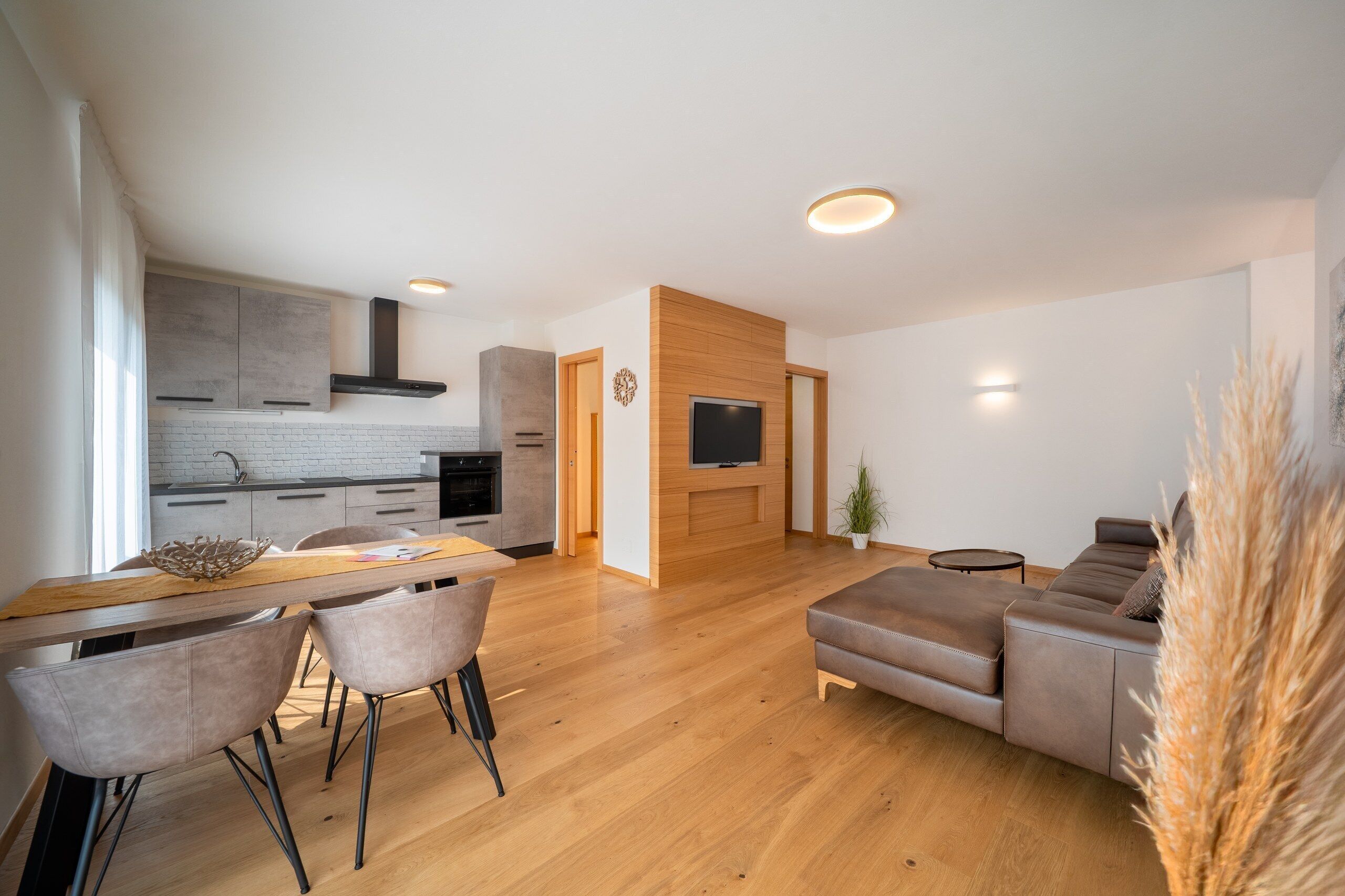 A modern living space with a kitchen, dining area, and a seating area.