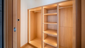 A walk-in closet with wooden shelving and a door with a handle.
