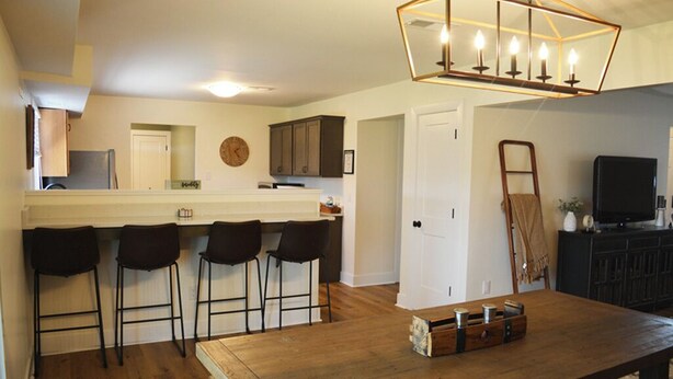 A kitchen with a bar area, wooden flooring, and a chandelier. - Home in Frankfort countryside-close to distilleries, Keeneland &Churchill Downs! (Frankfort)
