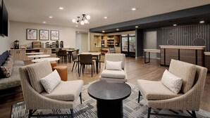 A modern lounge area with sofas, a coffee station, and a counter with snacks. - Hyatt Studios Huntsville (Huntsville)