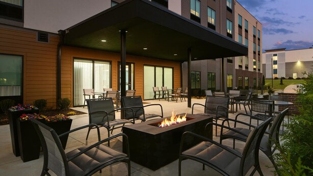 An outdoor patio area with a fire feature, seating, and a covered section. - Hyatt Studios Huntsville (Huntsville)