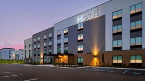 A modern hotel building with a prominent "Hyatt Studios" sign, multiple floors, and a parking lot with handicapped-accessible spaces. - Hyatt Studios Huntsville (Huntsville)