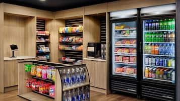 A self-service snack and drink kiosk with shelves stocked with various snacks and bottled water.