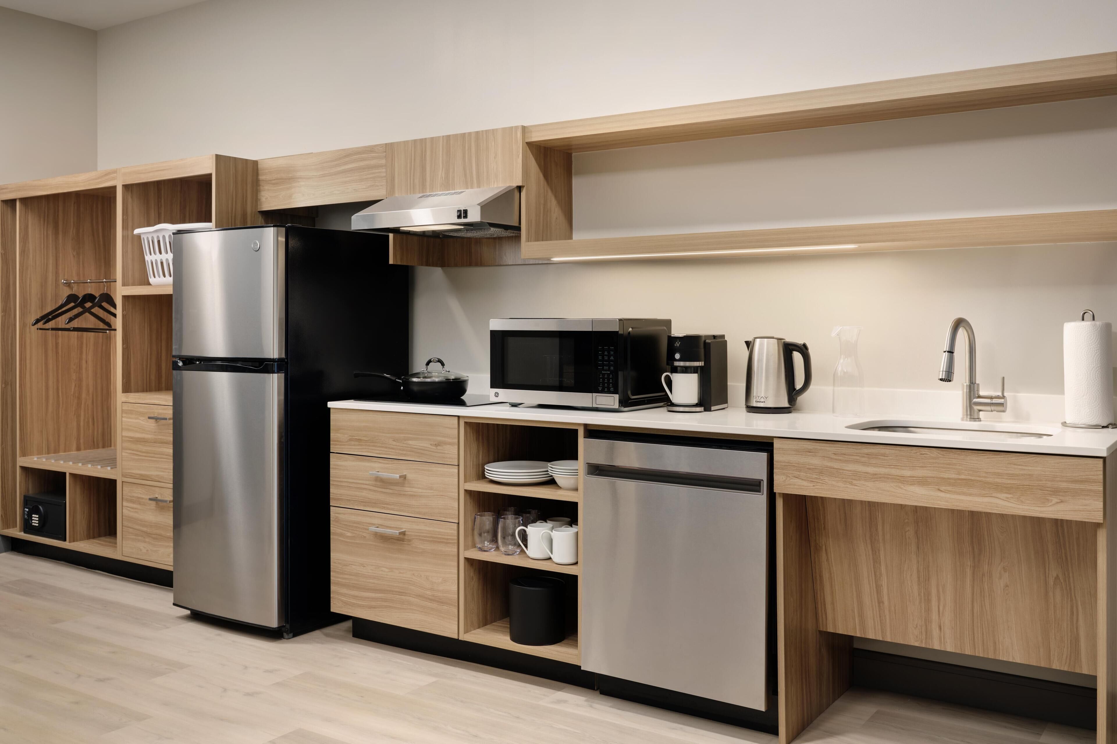 A modern kitchen with a stainless steel refrigerator, microwave, and coffee maker.