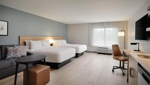 A hotel room with two beds, a desk, a chair, a sofa, and a TV. - Hyatt Studios Huntsville (Huntsville)