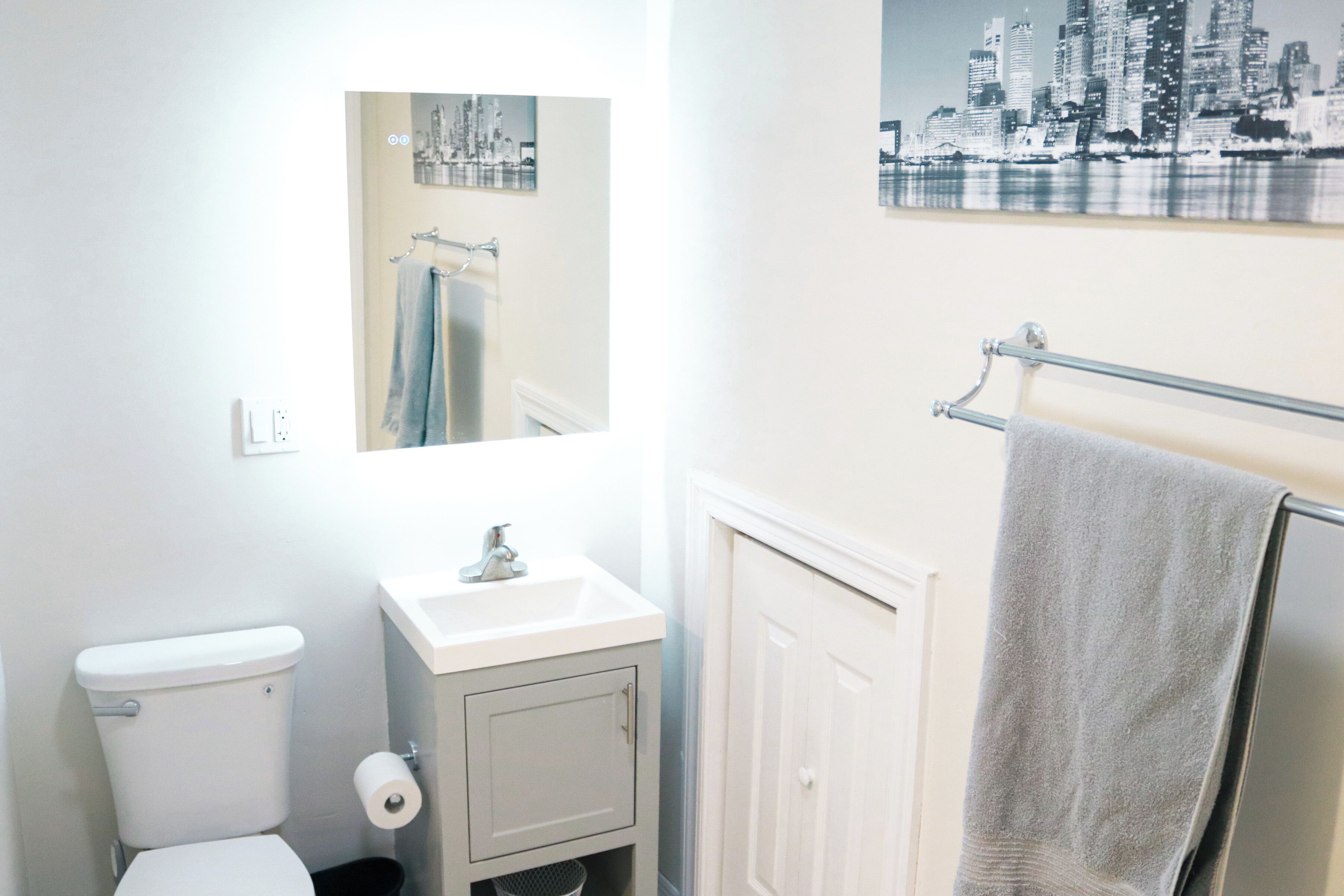 A bathroom with a toilet, sink, and towel rack.