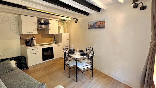 Um espaço compacto com área de refeições, cozinha compacta e sofá.