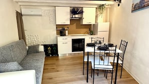 Um espaço compacto com cozinha compacta, área de jantar e área de estar.