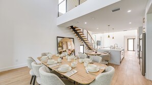 A spacious dining area with a high ceiling and a staircase leading to an upper level. - 3 Mi to Naples Beach: Luxurious Home w/ Pool! (Naples)