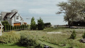 A residential property with a fenced yard, a large tree, and a view of the water.