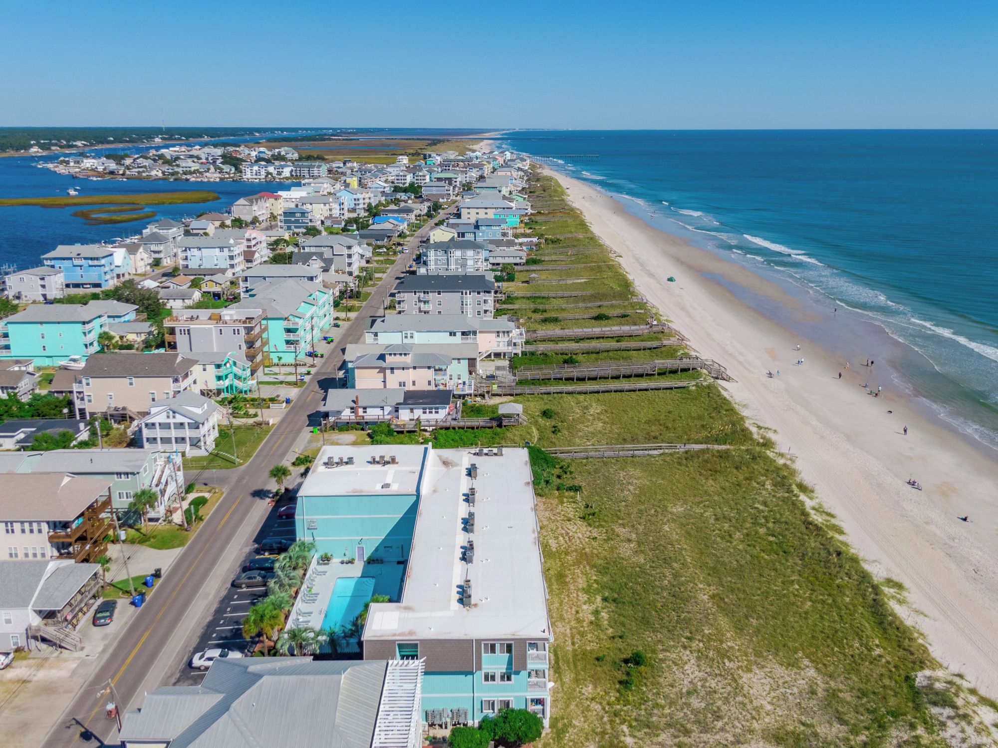Une ville côtière dotée d’une longue plage, d’alignées de maisons et offrant une vue dégagée sur l’océan.