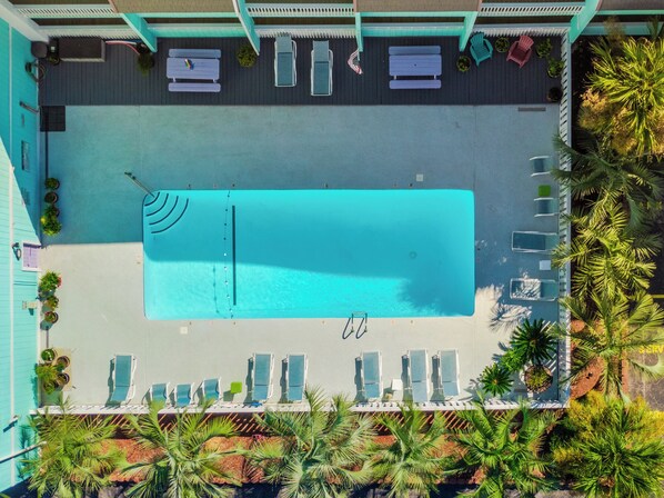 An aerial view of a pool area with lounge chairs and a pool. - A Place At The Beach #1a- Badabing by Carolina Retreats (Carolina Beach)