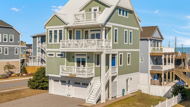 Ein zweistöckiges Haus mit Veranda, Garage und einer sichtbaren Hausnummer.